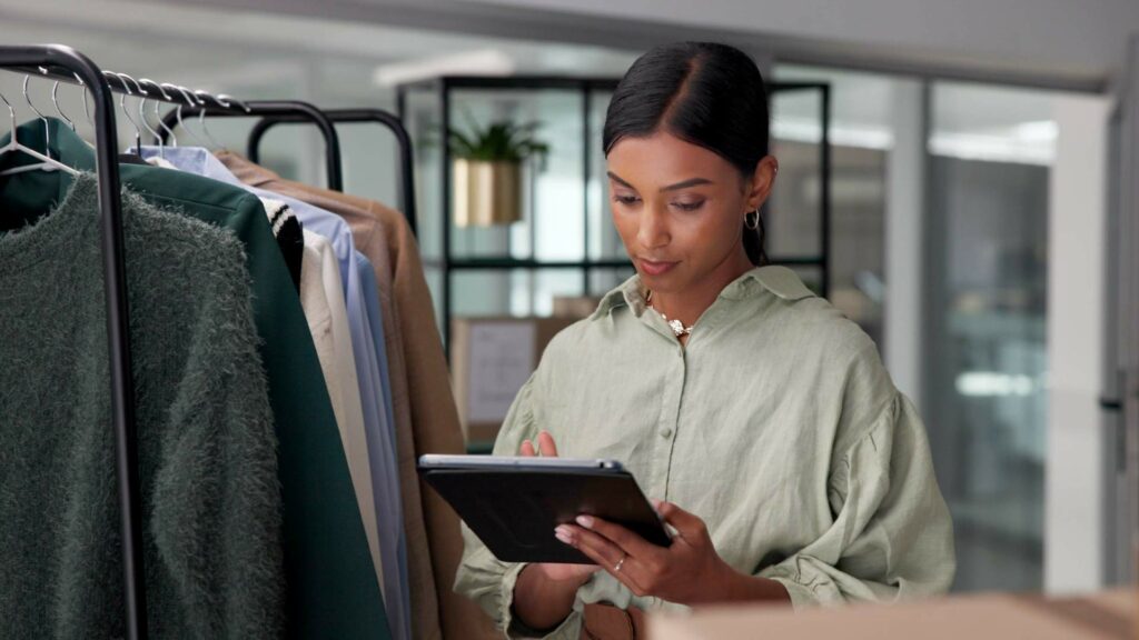 Persona che guarda il tablet in un negozio di abbigliamento